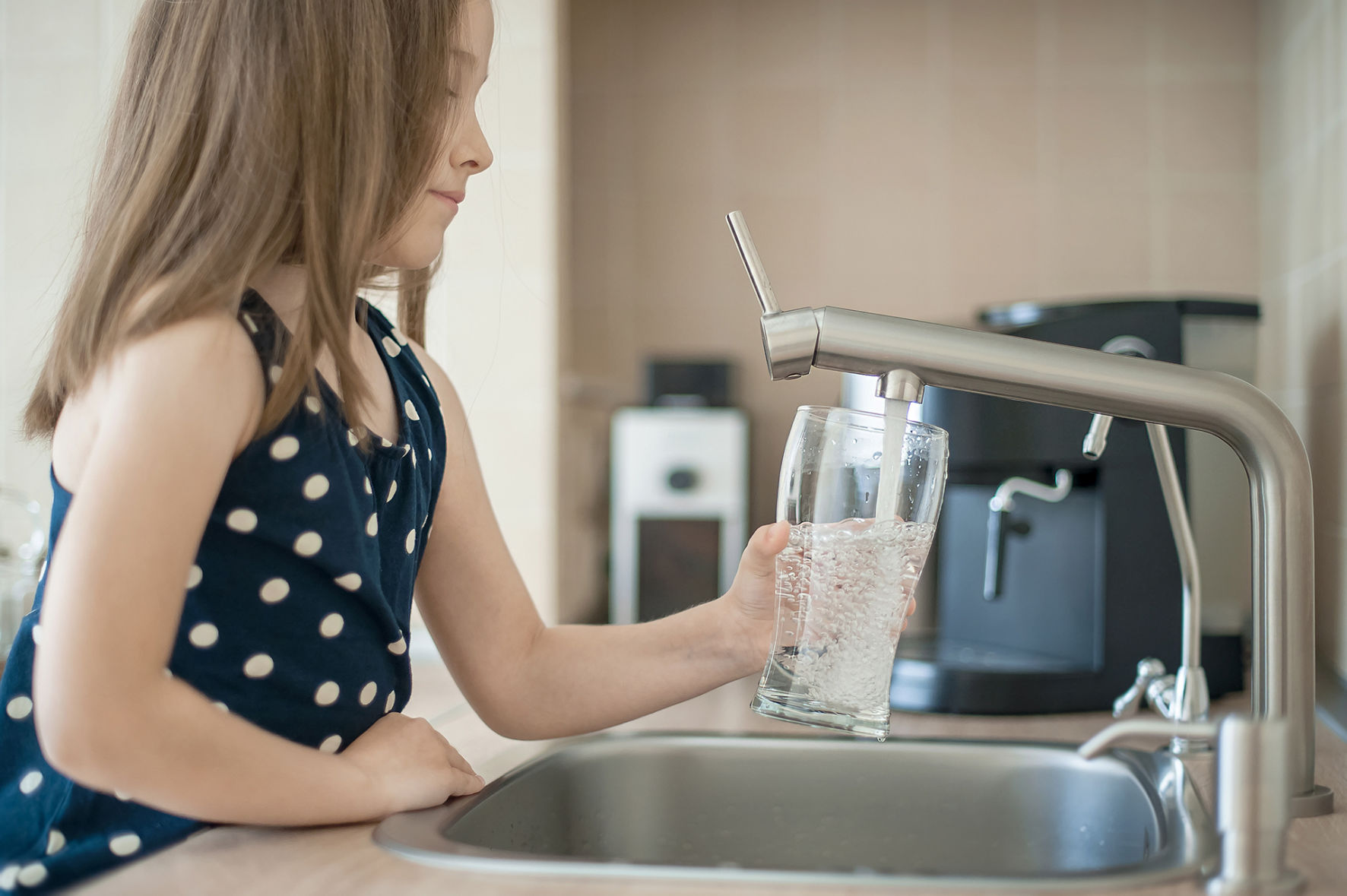 Fillette avec un verre d'eau du robinet